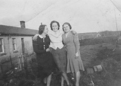 Three women in 1940s fashion in the garden of a house