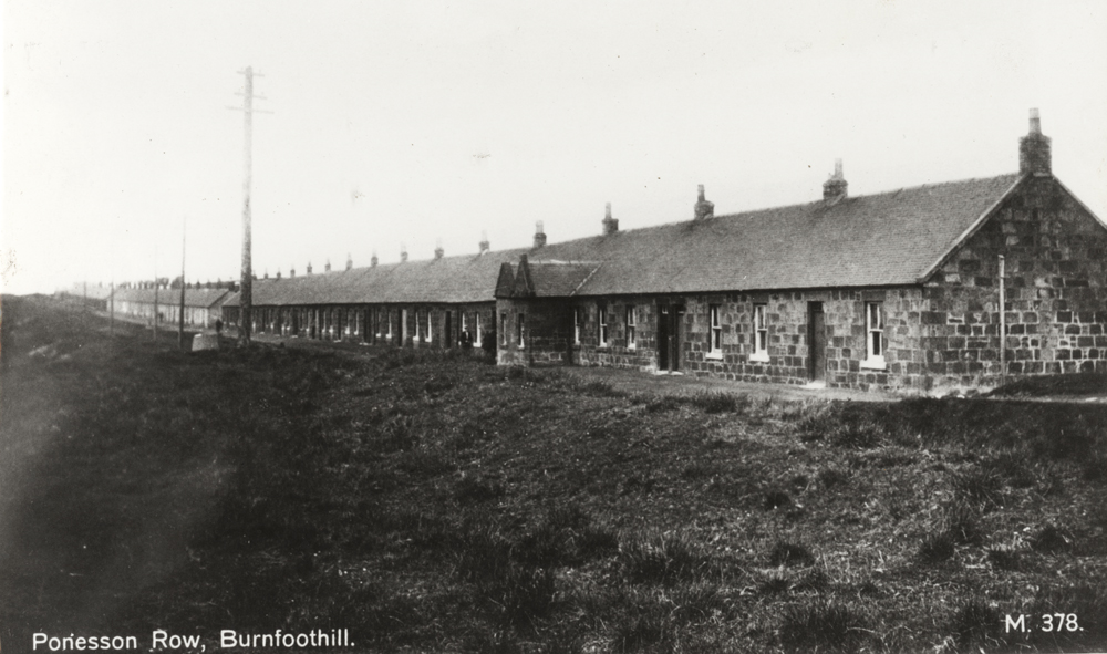 Row of single storey stone build housing that stretches off into the distance from right to left.